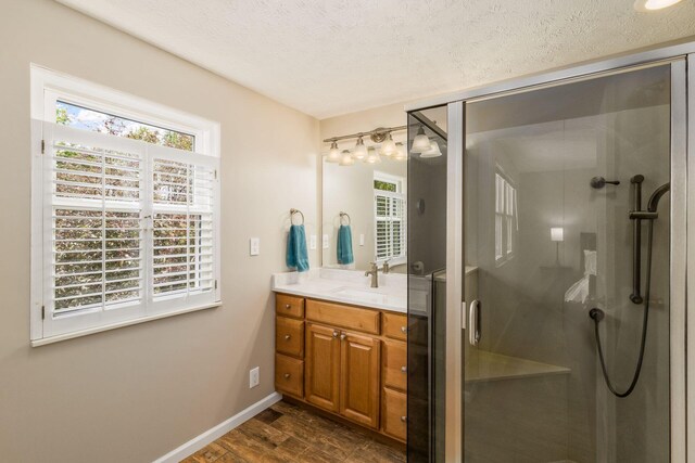 3690 Christopher Pl, Grove City, OH 43123 - bathroom with vanity, a shower stall, wood finished floors, a textured ceiling, and baseboards