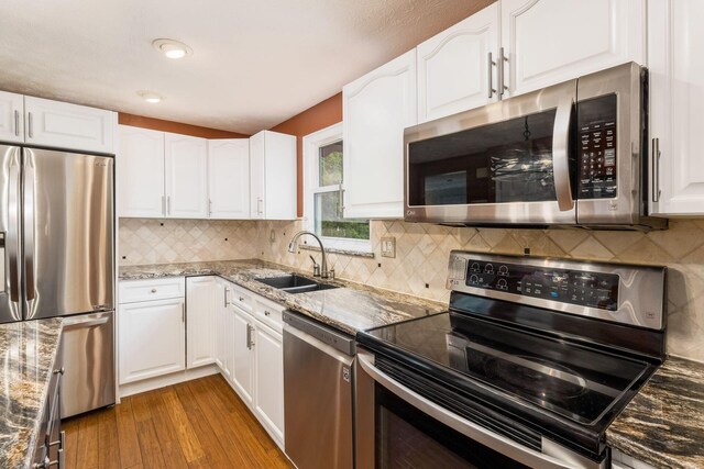 3690 Christopher Pl, Grove City, OH 43123 - kitchen with stainless steel appliances, a sink, dark wood finished floors, stone countertops, and white cabinets