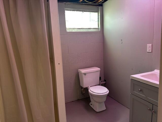 3128 Parsons Ave, Columbus, OH 43207 - bathroom with toilet, vanity, and concrete block wall