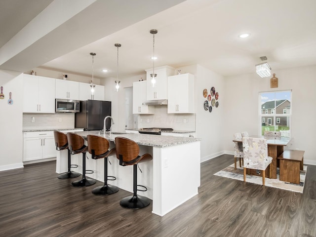 418 Amethyst Ct, Delaware, OH 43015 - kitchen with stainless steel microwave, freestanding refrigerator, dark wood-type flooring, tasteful backsplash, and recessed lighting
