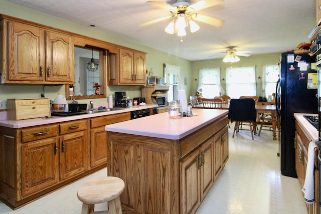 1320 Oakridge Dr, Bucyrus, OH 44820 - kitchen with black appliances, a ceiling fan, brown cabinets, and a center island