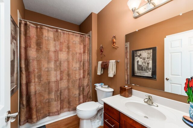 6227 Marias Point Ln, Columbus, OH 43213 - bathroom with toilet, a shower with shower curtain, vanity, a textured ceiling, and wood finished floors