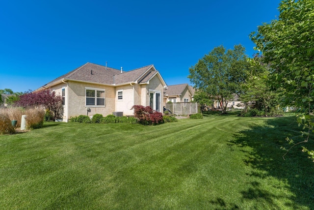 6227 Marias Point Ln, Columbus, OH 43213 - rear view of property with stucco siding, a lawn, and central AC unit