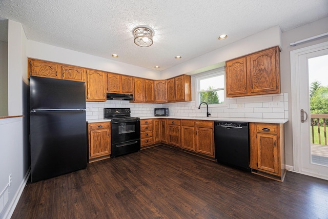 9721 State Rte 521, Sunbury, OH 43074 - kitchen with black appliances, under cabinet range hood, dark wood-type flooring, a textured ceiling, and recessed lighting