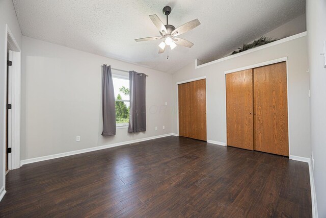 9721 State Rte 521, Sunbury, OH 43074 - unfurnished bedroom featuring lofted ceiling, two closets, dark wood-type flooring, a textured ceiling, and a ceiling fan
