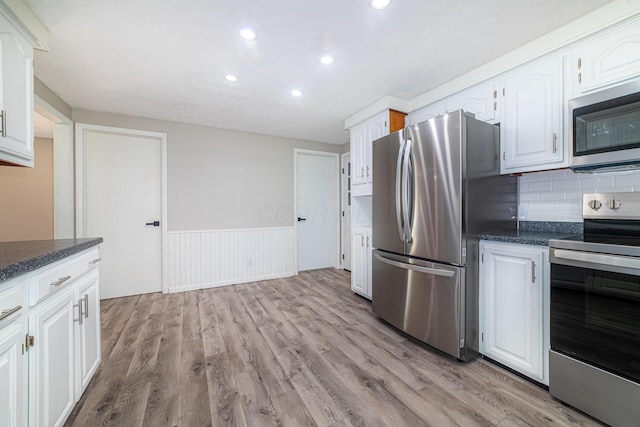 2814 Nesbitt Rd, Caledonia, OH 43314 - kitchen featuring appliances with stainless steel finishes, light wood finished floors, white cabinets, a wainscoted wall, and recessed lighting