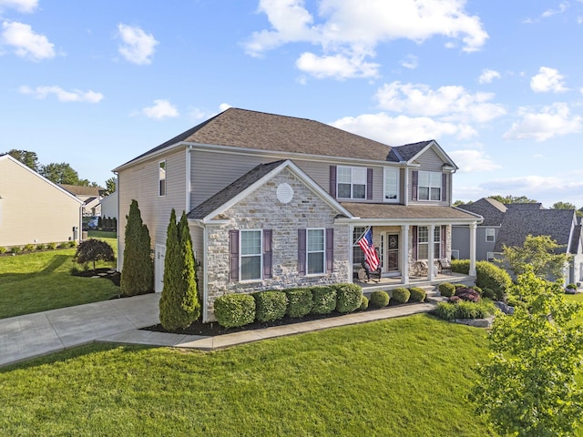 607 Green Forest Pl, Lithopolis, OH 43136 - view of front of house featuring stone siding, concrete driveway, a front yard, and covered porch