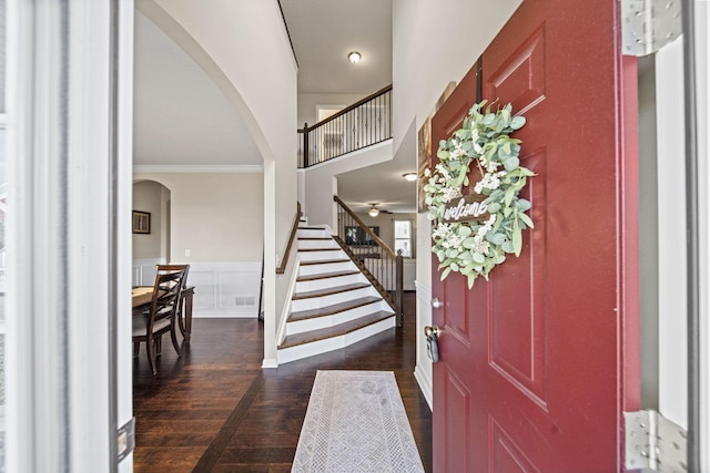 607 Green Forest Pl, Lithopolis, OH 43136 - foyer entrance featuring arched walkways, stairs, ornamental molding, dark wood finished floors, and a wainscoted wall