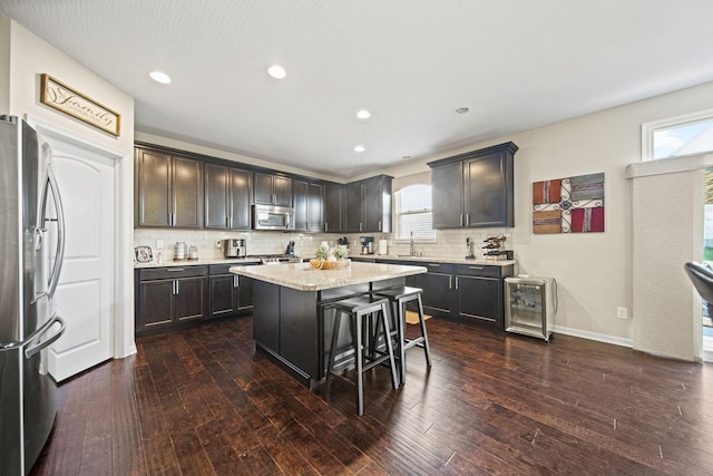 607 Green Forest Pl, Lithopolis, OH 43136 - kitchen featuring stainless steel appliances, wine cooler, dark wood-style floors, a kitchen island, and backsplash