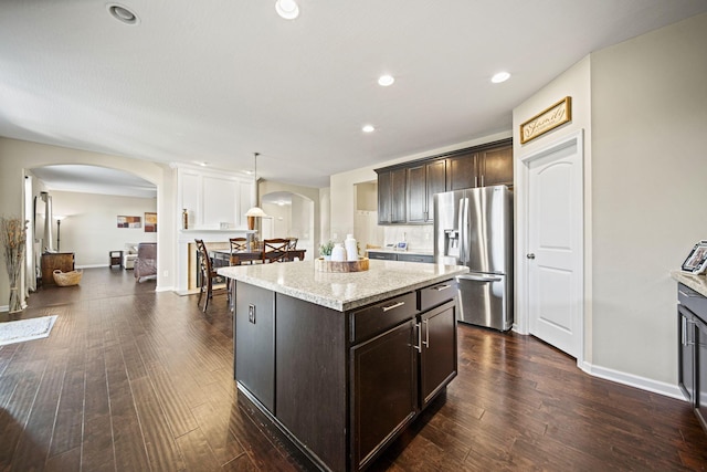 607 Green Forest Pl, Lithopolis, OH 43136 - kitchen with stainless steel refrigerator with ice dispenser, arched walkways, dark brown cabinets, dark wood-style flooring, and a kitchen island