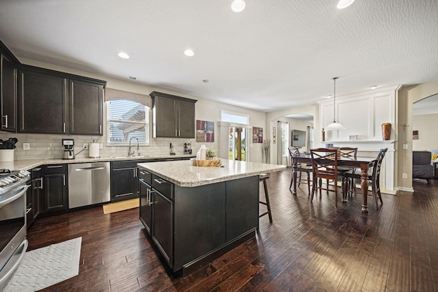 607 Green Forest Pl, Lithopolis, OH 43136 - kitchen with appliances with stainless steel finishes, arched walkways, a kitchen island, a sink, and backsplash