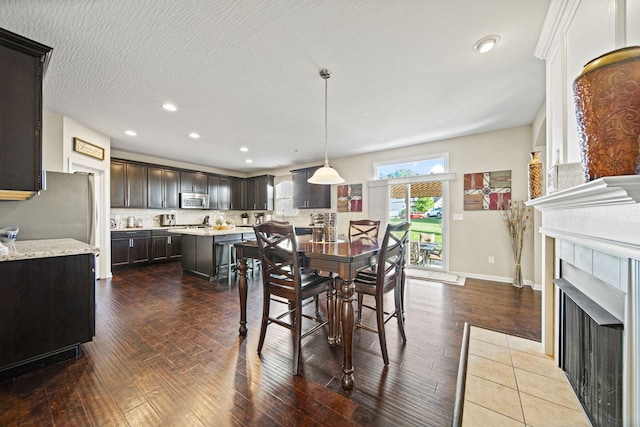607 Green Forest Pl, Lithopolis, OH 43136 - dining space featuring dark wood finished floors, recessed lighting, a tile fireplace, and baseboards