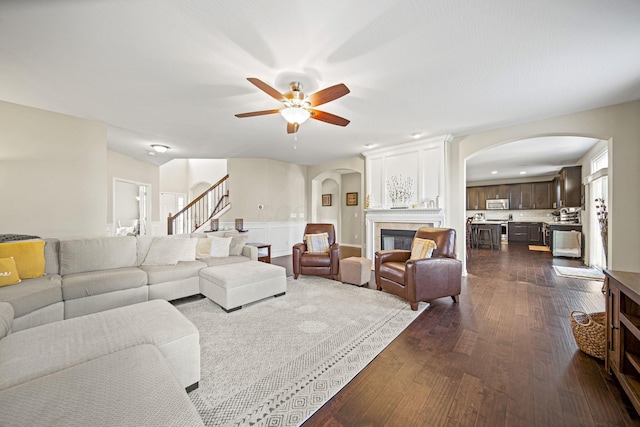 607 Green Forest Pl, Lithopolis, OH 43136 - living room with arched walkways, dark wood-style flooring, a ceiling fan, and stairs