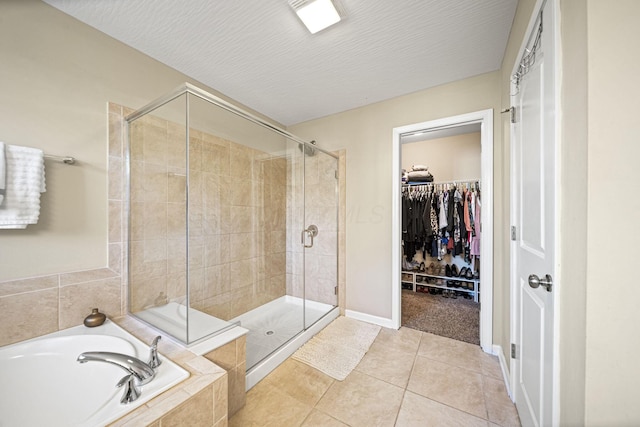 607 Green Forest Pl, Lithopolis, OH 43136 - full bathroom featuring a bath, a shower stall, tile patterned flooring, a walk in closet, and baseboards