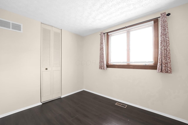 1235 Belle Meade Pl, Westerville, OH 43081 - unfurnished bedroom featuring dark wood finished floors, a textured ceiling, baseboards, and a closet