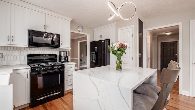 832 Mcleod Parc, Pickerington, OH 43147 - kitchen featuring black appliances, light wood-style floors, backsplash, white cabinets, and a kitchen island
