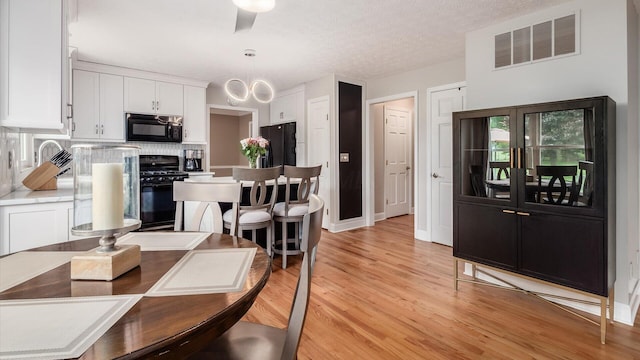 832 Mcleod Parc, Pickerington, OH 43147 - dining space featuring light wood-style flooring, baseboards, a chandelier, and a textured ceiling