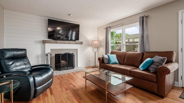 832 Mcleod Parc, Pickerington, OH 43147 - living room with wood finished floors, a brick fireplace, a textured ceiling, and wood walls