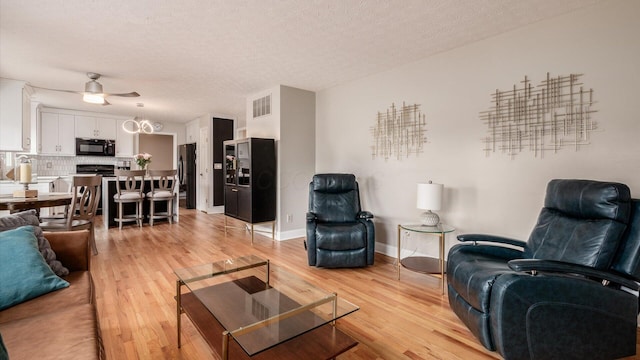 832 Mcleod Parc, Pickerington, OH 43147 - living room featuring ceiling fan, light wood-style floors, baseboards, and a textured ceiling