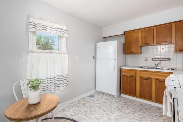 1310 Acton Rd, Columbus, OH 43224 - kitchen featuring freestanding refrigerator, a sink, stove, and brown cabinetry