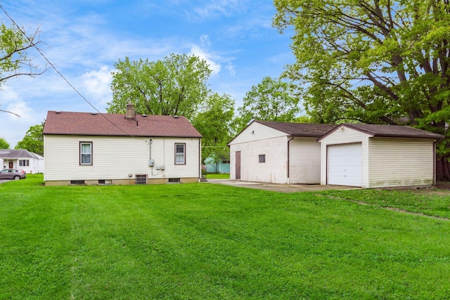 1310 Acton Rd, Columbus, OH 43224 - back of property featuring an outdoor structure, a lawn, and a detached garage