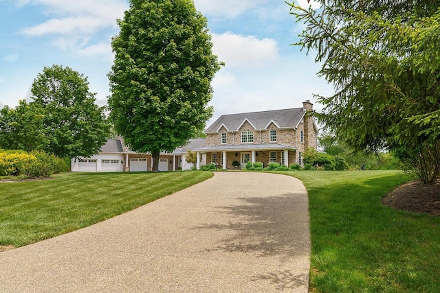 6008 Shala Cir, Nashport, OH 43830 - view of front of house with driveway, a front yard, a chimney, and stone siding