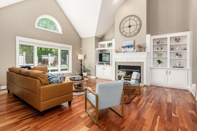 living room featuring high vaulted ceiling, a fireplace, wood finished floors, and baseboards
