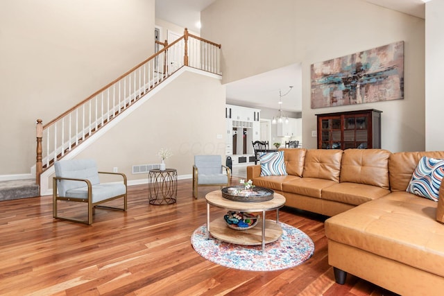 living area featuring a high ceiling, wood finished floors, and stairs