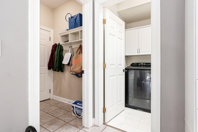 clothes washing area featuring washer / dryer, cabinet space, and baseboards