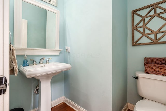 half bath with toilet and baseboards