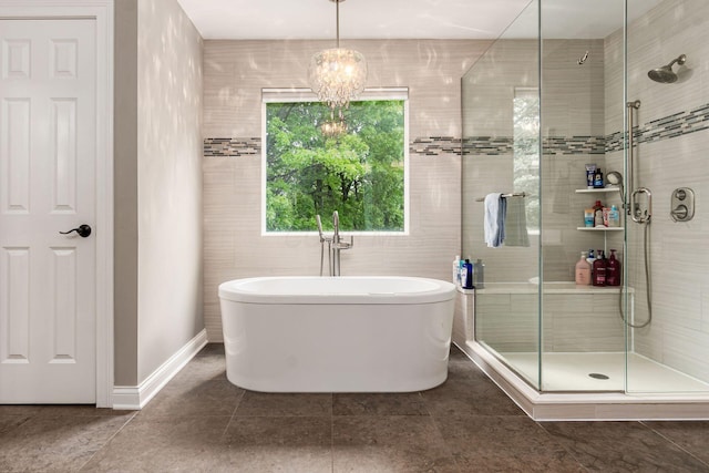 full bathroom featuring a stall shower, a soaking tub, tile patterned floors, and baseboards