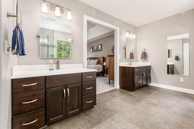 ensuite bathroom with two vanities and baseboards