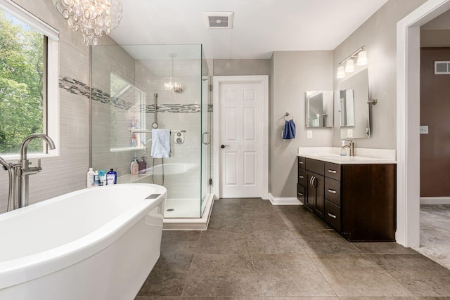 full bathroom with a chandelier, vanity, baseboards, and a shower stall