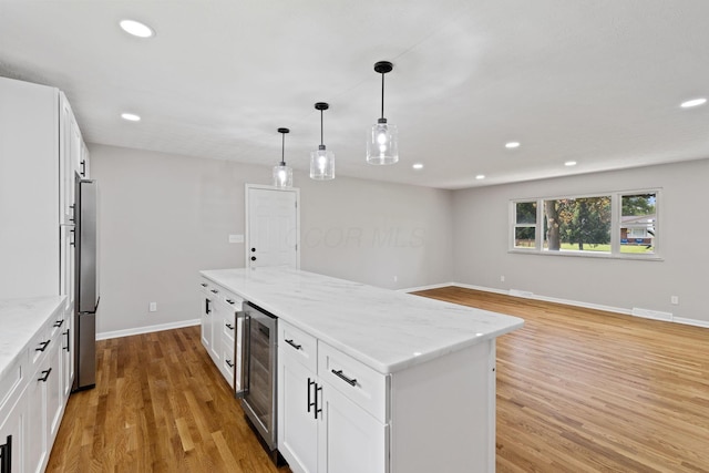 kitchen with wine cooler, recessed lighting, light stone countertops, light wood-style floors, and white cabinetry