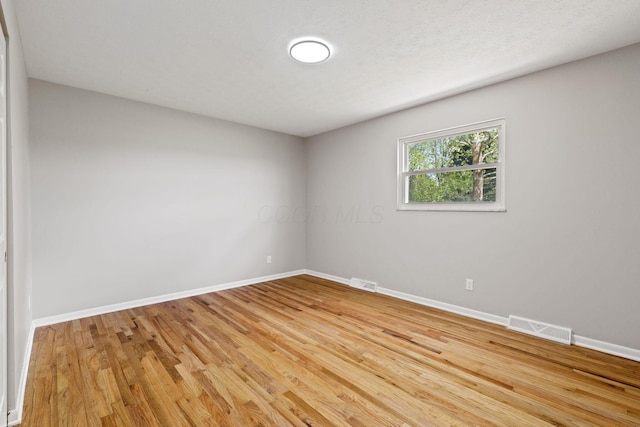 unfurnished room featuring baseboards and light wood-style flooring