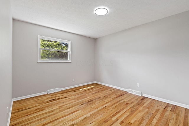 spare room featuring baseboards and wood finished floors
