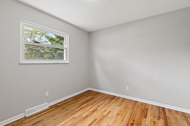 spare room featuring baseboards and light wood-type flooring