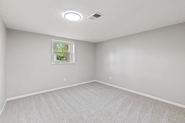 unfurnished room featuring carpet, baseboards, and a textured ceiling