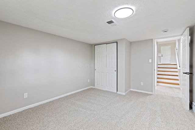 unfurnished bedroom featuring light carpet, baseboards, and a closet