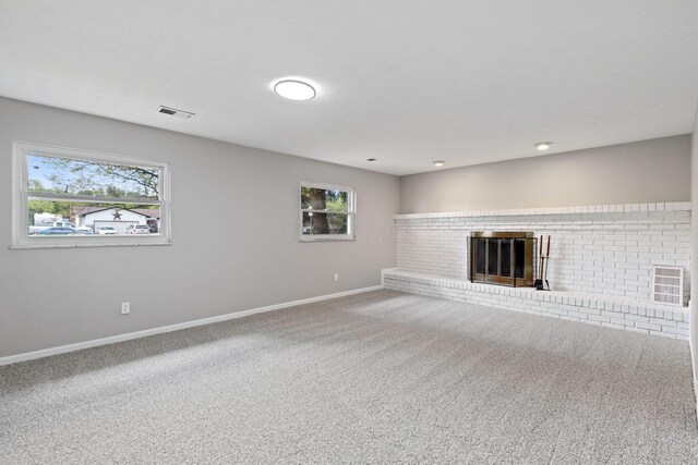 unfurnished living room with baseboards, carpet flooring, and a fireplace
