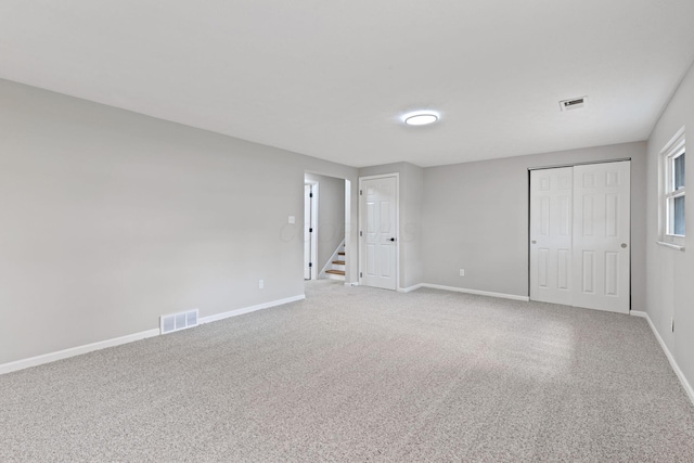 unfurnished bedroom featuring baseboards, light colored carpet, and a closet