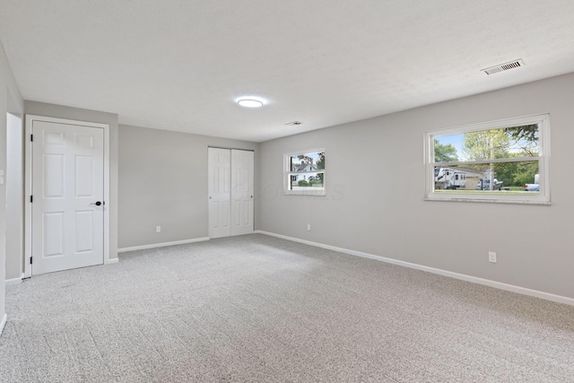 unfurnished bedroom with baseboards, carpet floors, and a closet