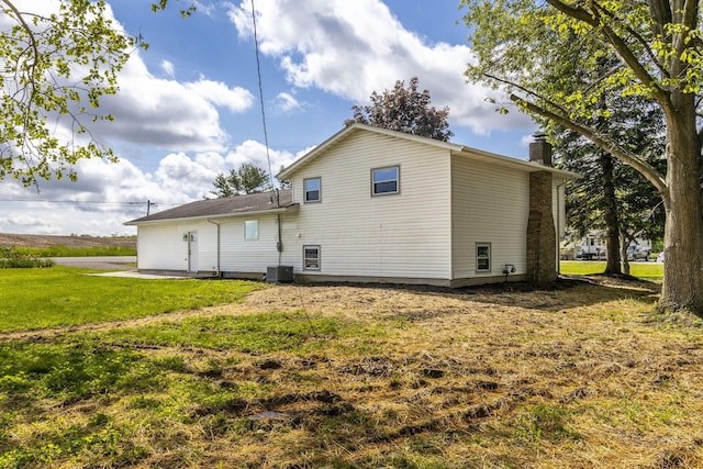 rear view of property with a chimney and a yard