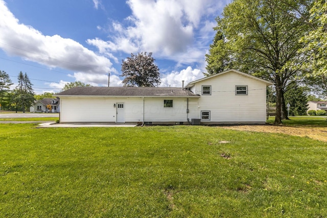 back of property featuring a yard, central AC unit, and a patio area