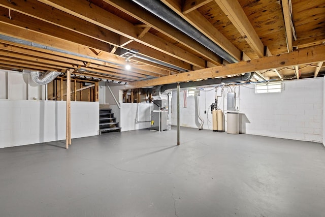 below grade area with heating unit, stairs, concrete block wall, and a water softener