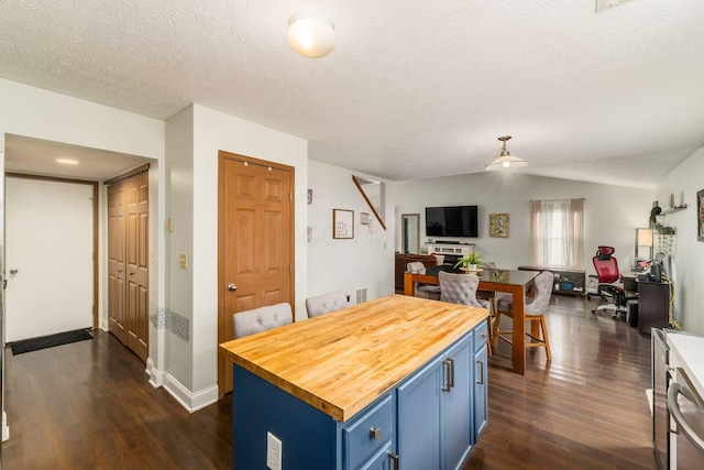 3854 Sugarbark Dr, Canal Winchester, OH 43110 - kitchen featuring blue cabinetry, butcher block countertops, dark wood-style flooring, open floor plan, and a textured ceiling
