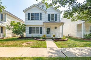 traditional-style home with a front yard and covered porch