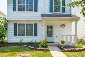 property entrance featuring covered porch and a yard