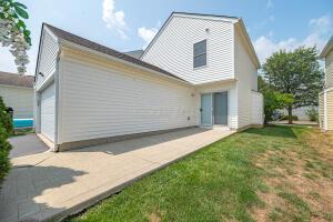 back of property with a lawn and a garage