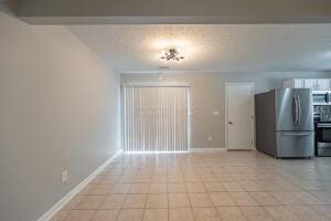 unfurnished dining area featuring baseboards and light tile patterned floors